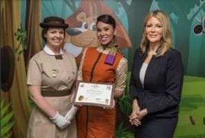 Linda Celestino, vicepresidenta de Experiencias de los Clientes de Etihad Airways (derecha), presenta a la niñera a bordo número 2.000 de la aerolinea, la española Isabel Moya Guzmán (centro), un certificado hecho expresamente para la ocasión.