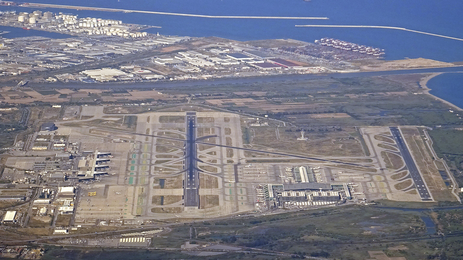 Vista aérea del aeropuerto de Barcelona el Prat con parte de la zona franca y el puerto en la zona superior de la foto.