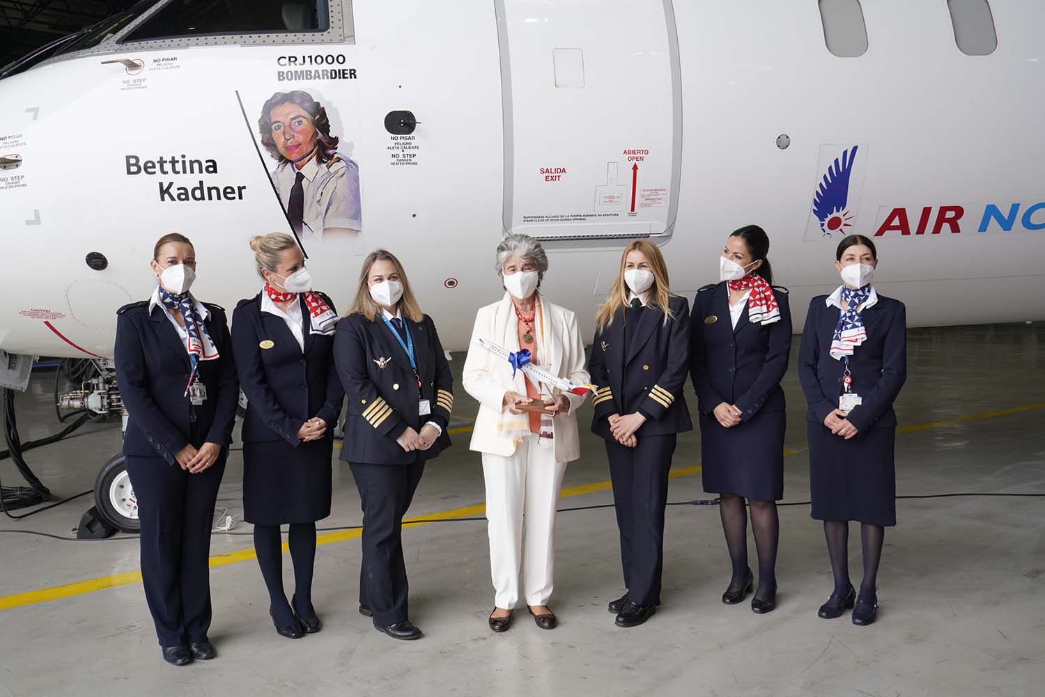 Bettina Kadner, de blanco, junto a Paz Ferrer y la tripulación del primer vuelo del avión.