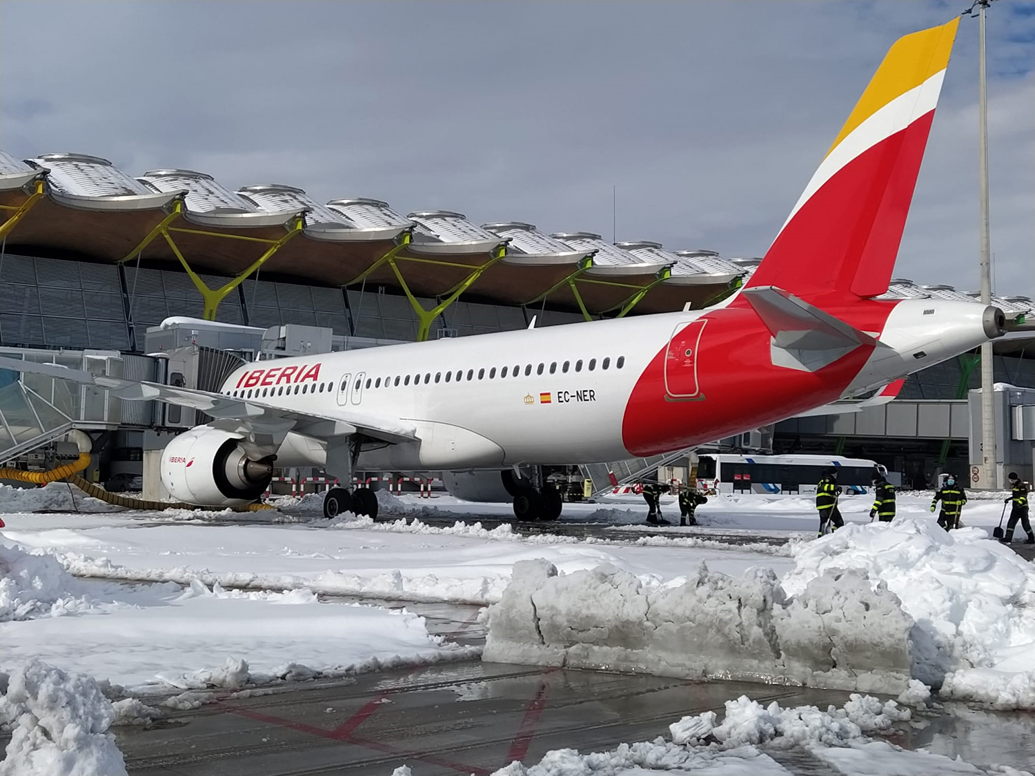 Airbus A350 de Iberia en la plataforma nevada del satélite de la T4 de Barajas.