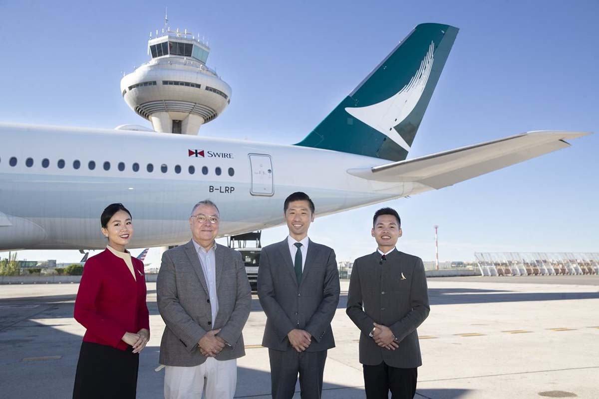 Ignacio Aznar, jefe Gabinete de Dirección de Aena y Kinto Chan, director general de Cathay Pacific para Europa junto a dos tripulantes del vuelo inaugural.