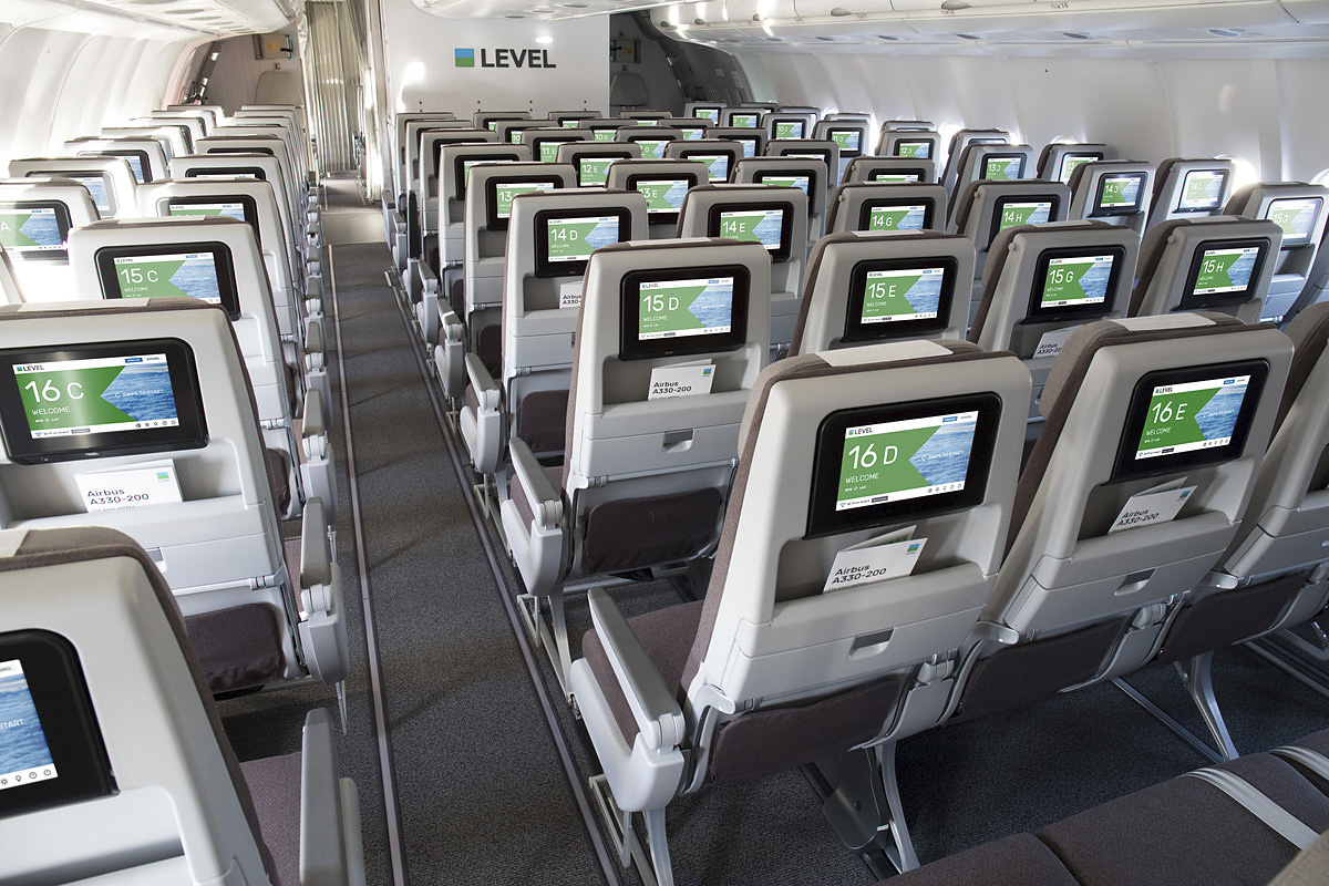 Cabina de pasaje de Level con las pantallas de entretenimiento a bordo en cada butaca.