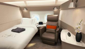 Cabina de primera clase de Singapore Airlines con cama y asientos separados.