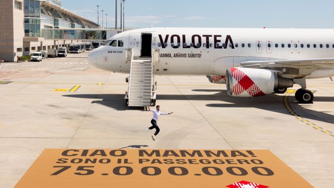 Fabio Bonaiuto, pasajero 75 millones frrente al avión de Volotea en que voló y el mayor felpudo del mundo.