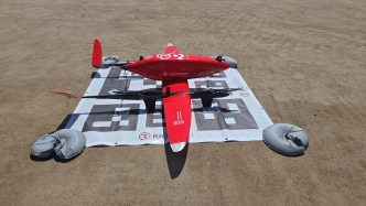 El UAV Eiger usado en la prueba en Santiago de Chile sobre la zona de aterrizaje. El código tipo QR impreso permite al dron identificarla y aterrizar de forma automática.