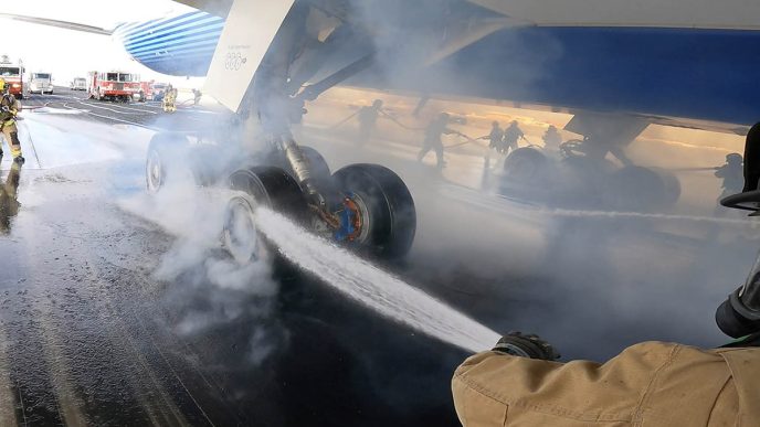 Los bomberos enfriando las ruedas y frenos del Boeing 777-9 tras la prueba de frenado máximo.